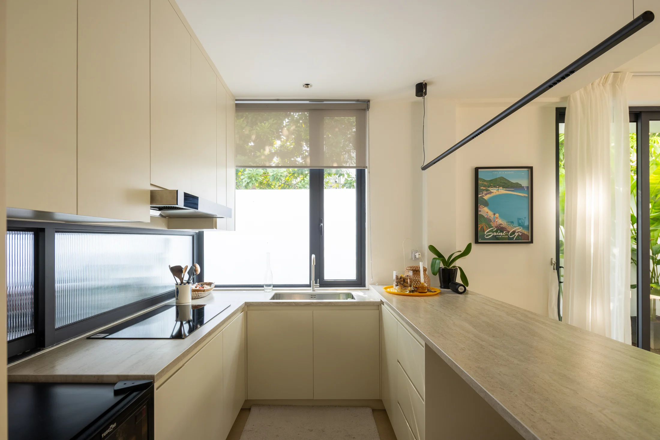 Close view of the kitchen cabinetry, stone worktops and window