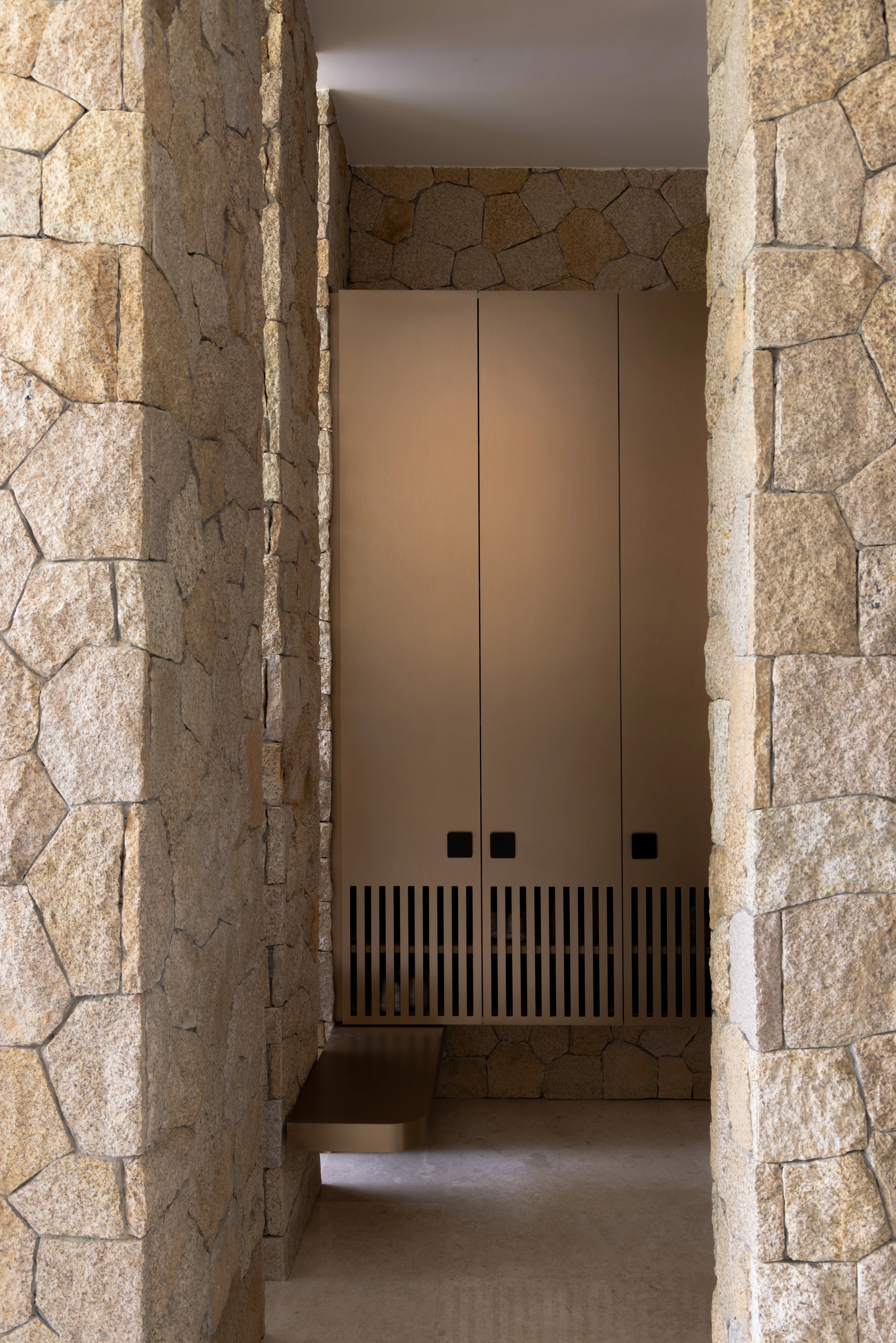 Stone-lined entrance and a timber bench