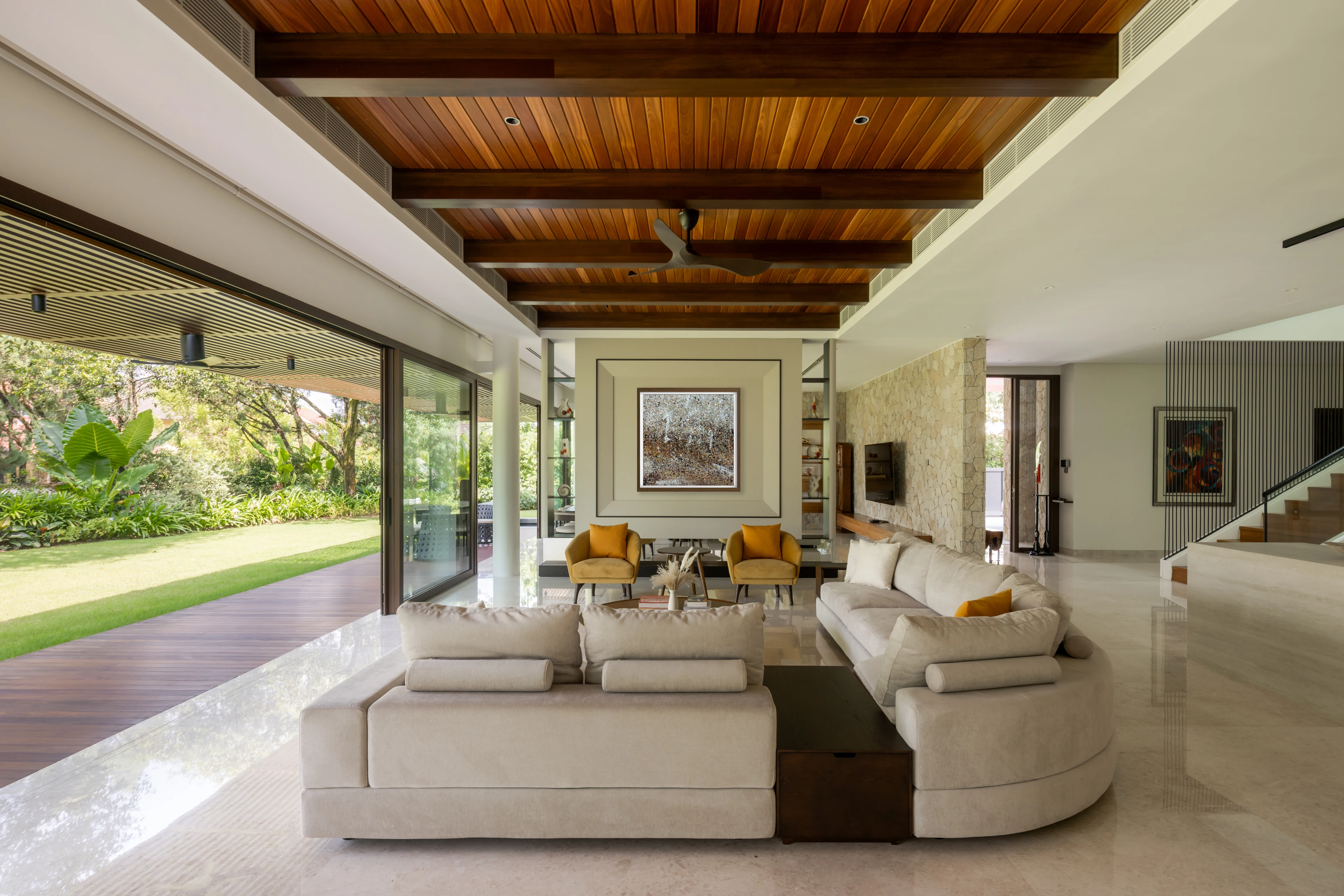 Living room with a timber ceiling opening towards the garden